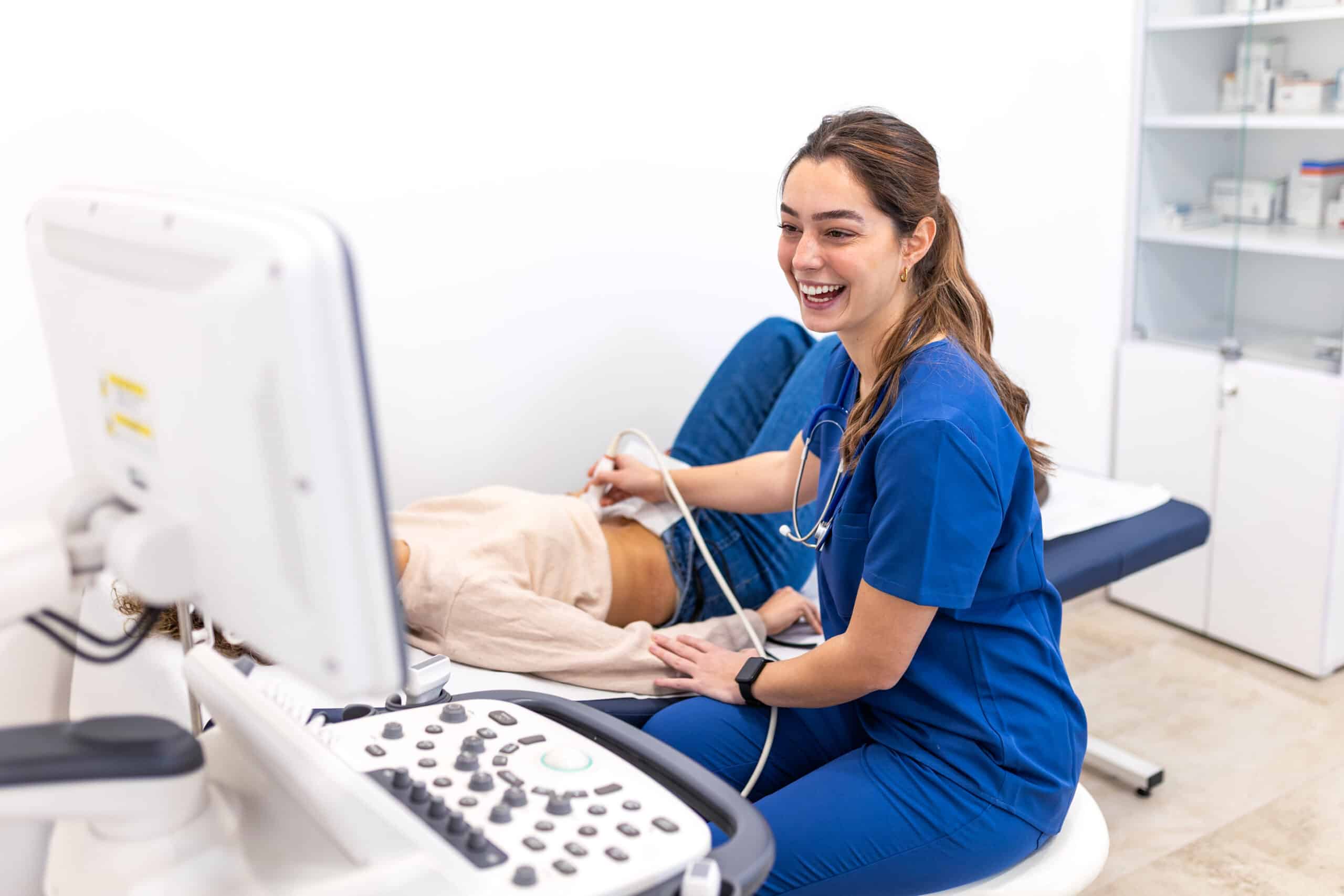 Smiling female doctor performing ultrasound scan on female patient in clinic. Professional medical diagnostic with sonogram machine in hospital. Healthcare, radiology and wellness concept image.
